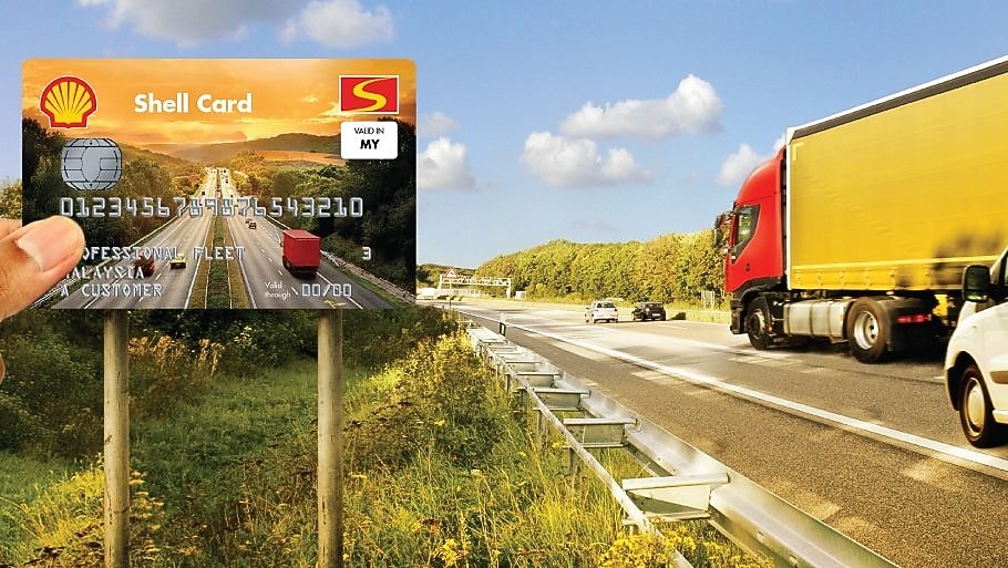 A truck and van on the road with the Shell Card held up in the foreground