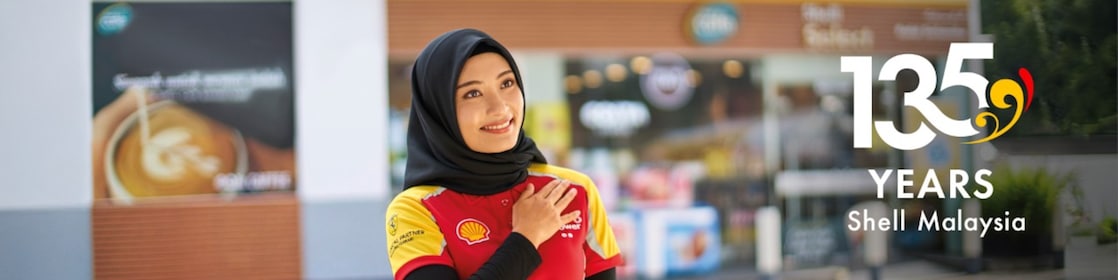 Shell Attendant greeting customers. Supported by the text “135 Years Shell Malaysia”
