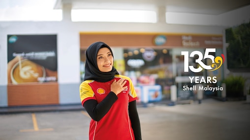 Shell Attendant greeting customers. Supported by the text “135 Years Shell Malaysia”