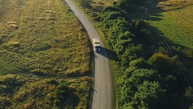 businessman overseeing three parked lorries