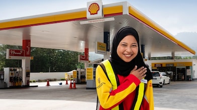 Shell attendant with hand on heart with Shell station