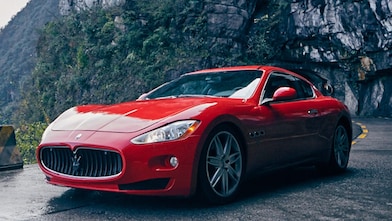 A red Maserati with standard Shell Helix Ultra product proudly sits on a scenic mountain road