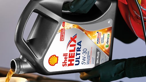 Man filling shell helix ultra oil in car