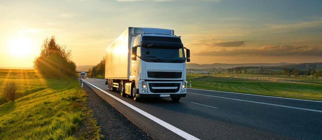 businessman overseeing three parked lorries
