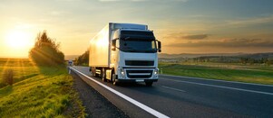 businessman overseeing three parked lorries