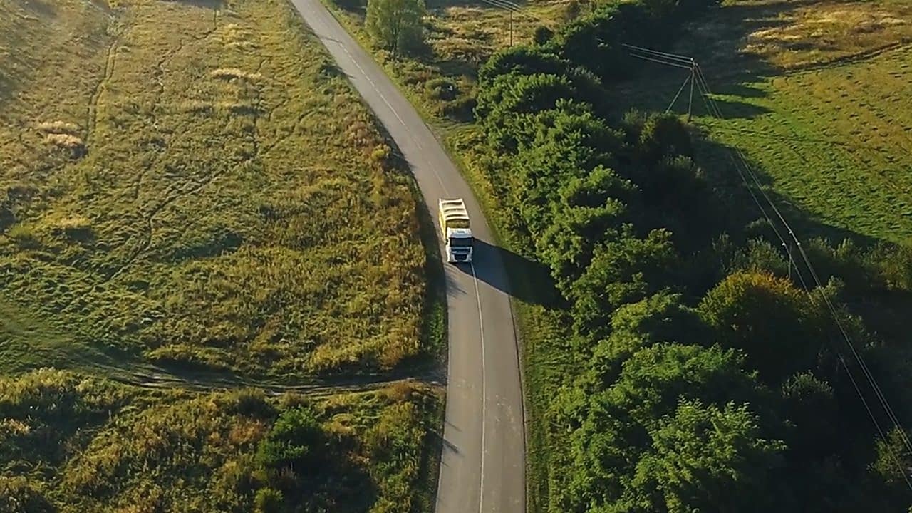 businessman overseeing three parked lorries