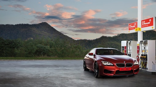 Red car in shell forecourt