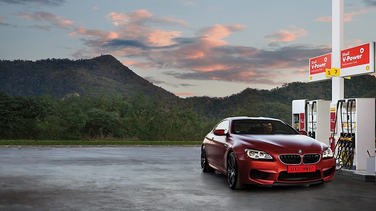 Red car in shell forecourt