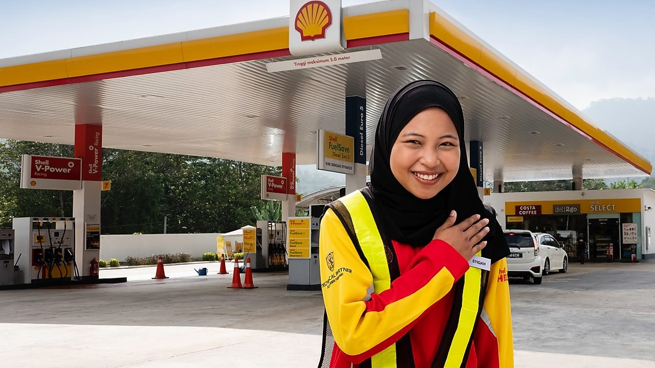 Shell attendant with hand on heart with Shell station