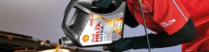 Man filling shell helix ultra oil in car