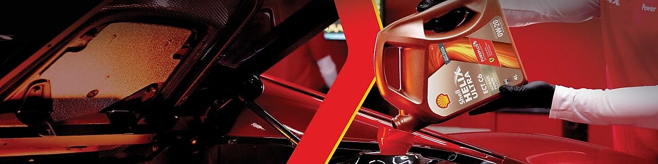 Man filling shell helix ultra oil in car