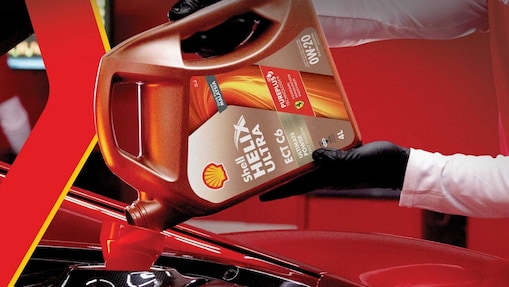 Man filling shell helix ultra oil in car