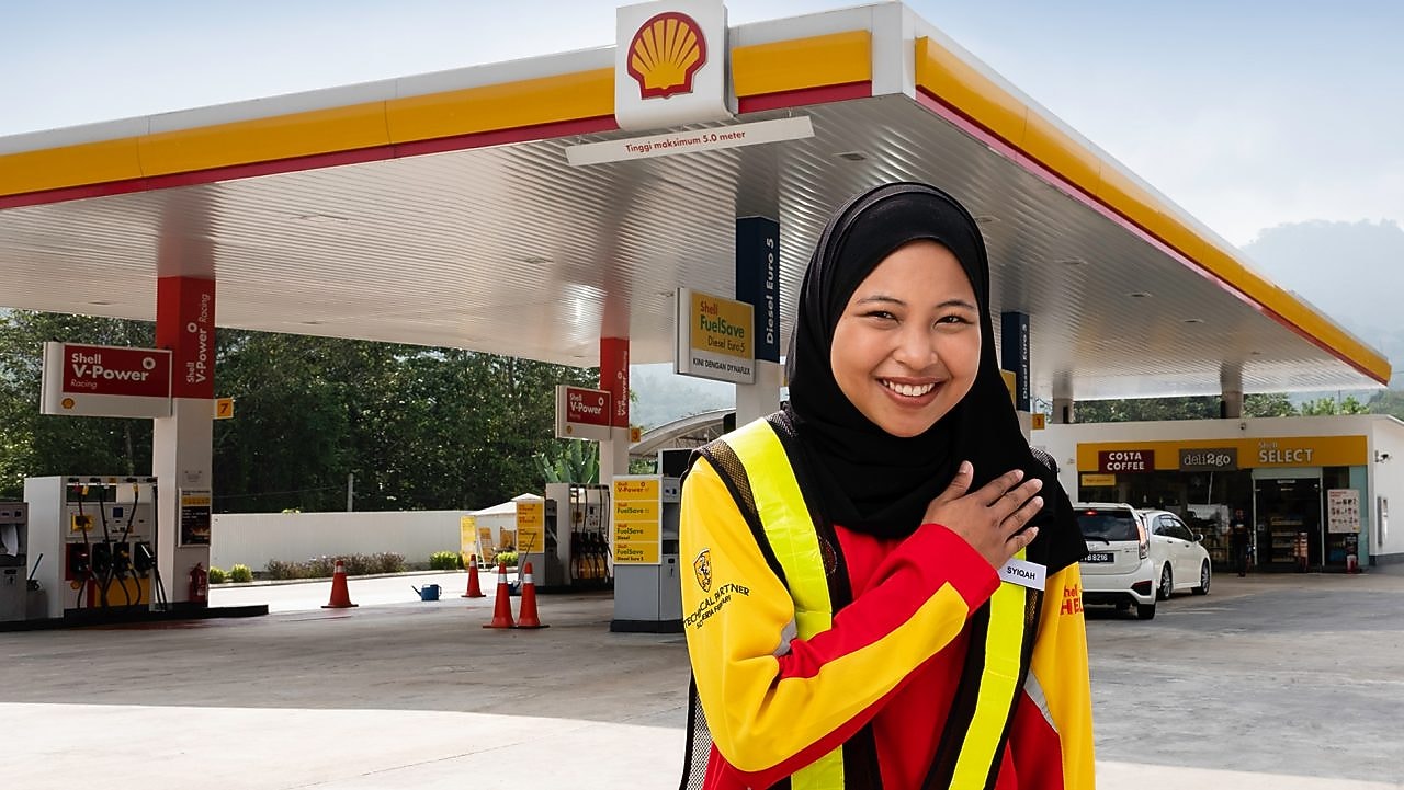 Shell attendant with hand on heart with Shell station