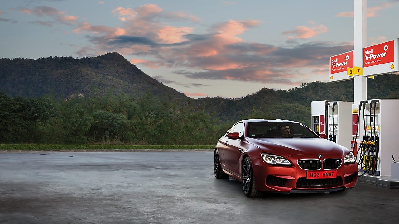 Red car in shell forecourt