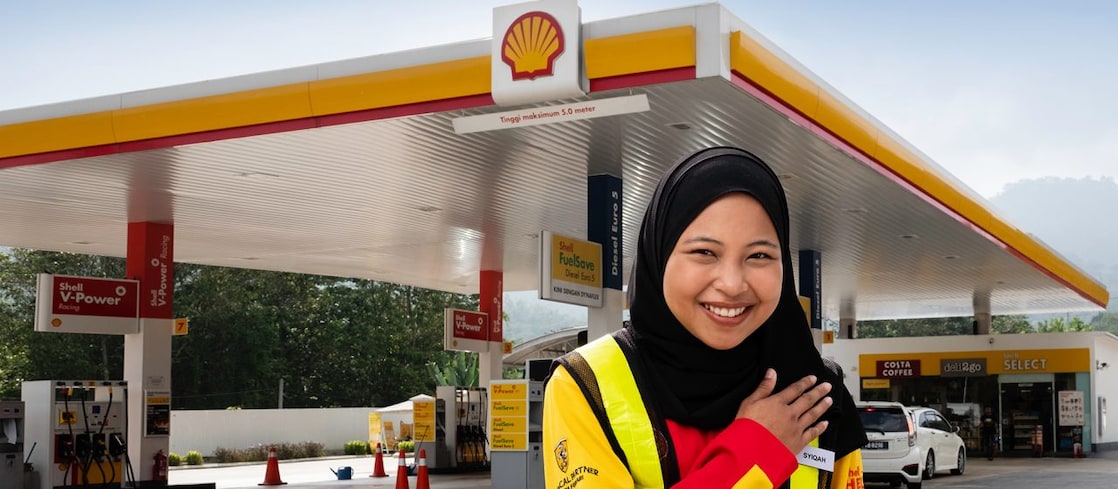 Shell attendant with hand on heart with Shell station