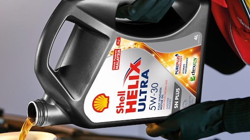 Man filling shell helix ultra oil in car