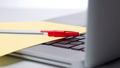 Laptop with pen and paper